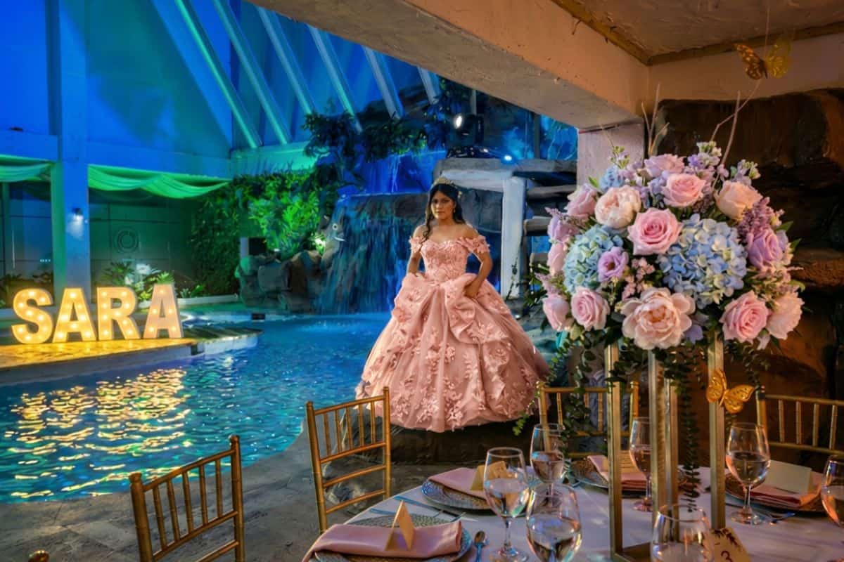 Montajes de lujo para fiestas de quinceaños con estructuras iluminadas y follaje.