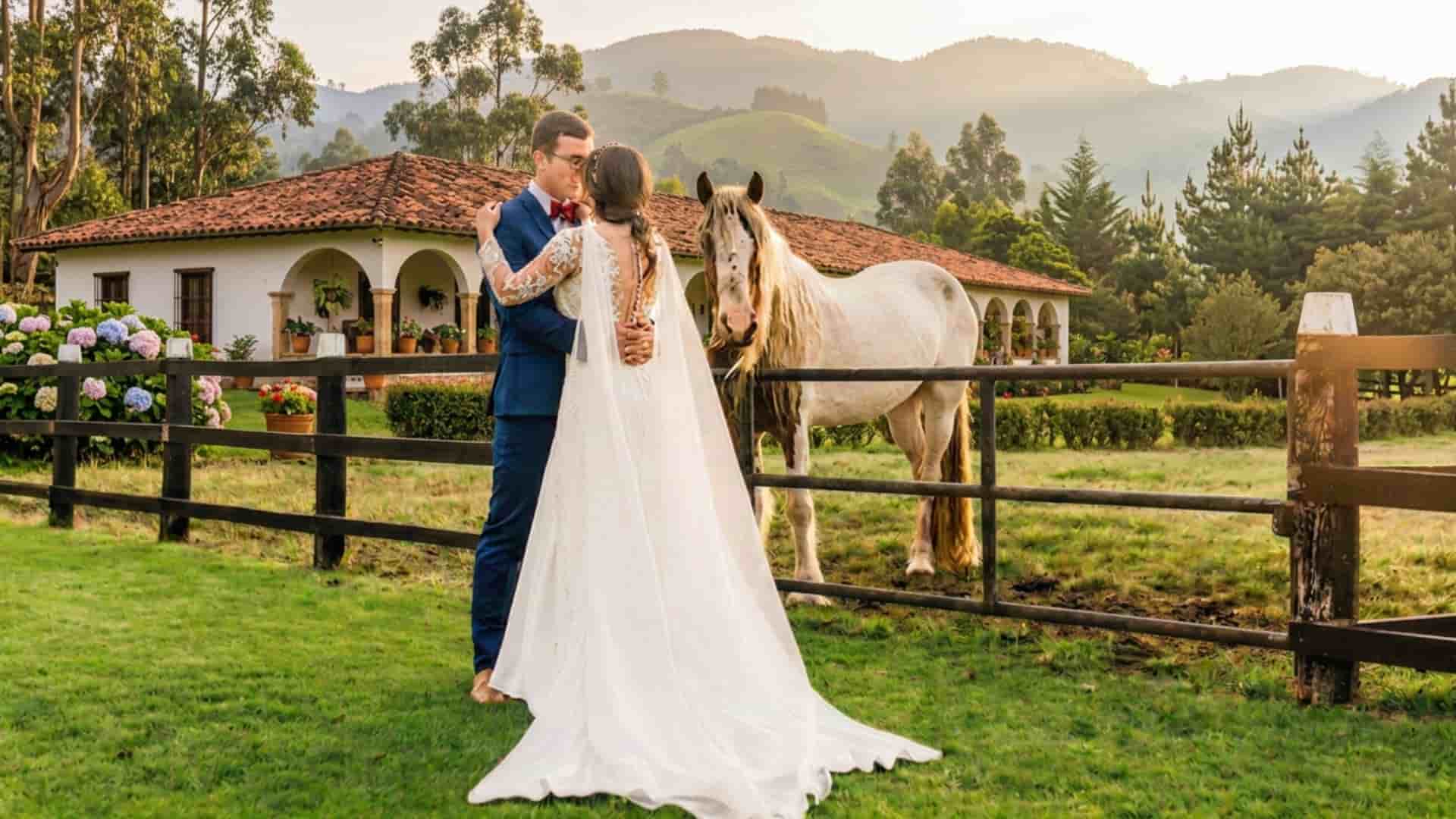 novios enamorados posando junto a un caballo de paso fino